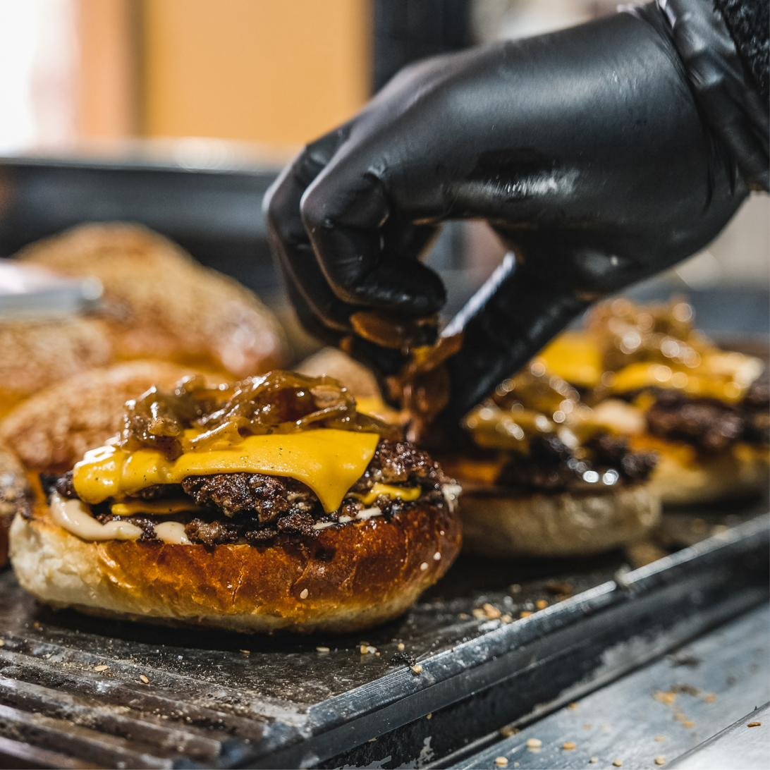 Smash burgers searing on the flat-top